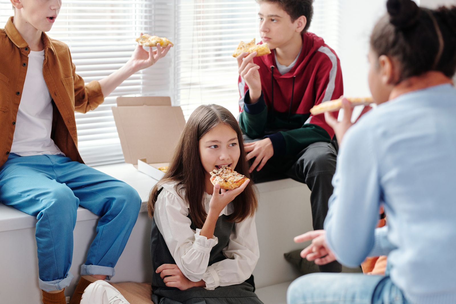 Teenagers sharing pizza together at a youth gathering
